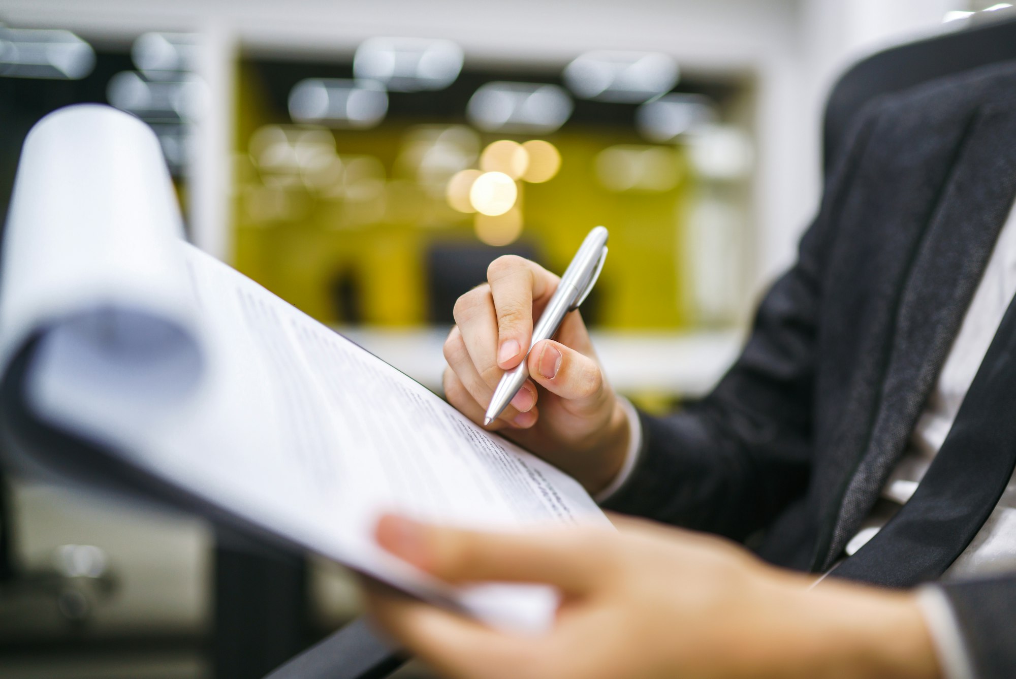A man signs a contrac, legal or business agreements. Male hand with pen makes notes.