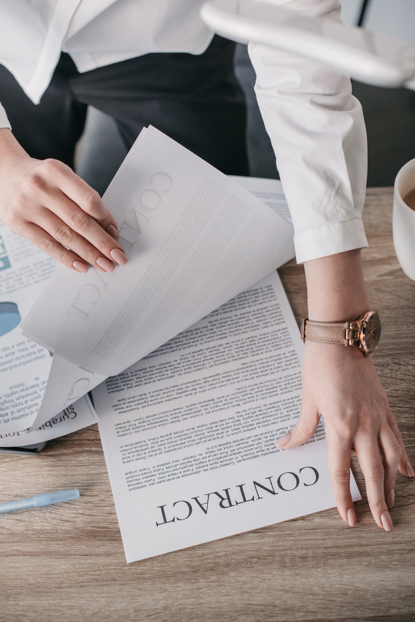 top view of young businesswoman reading contract documents in office